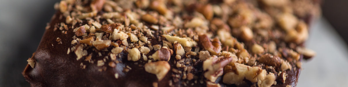 A close-up picture of a rich chocolate brownie with walnut crust